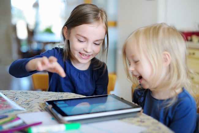deux enfants devant une tablette électronique