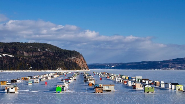 cabanes à pêche multicolores sur une rivière glacée