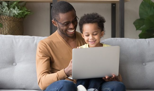 Smiling black dad and little son play computer game