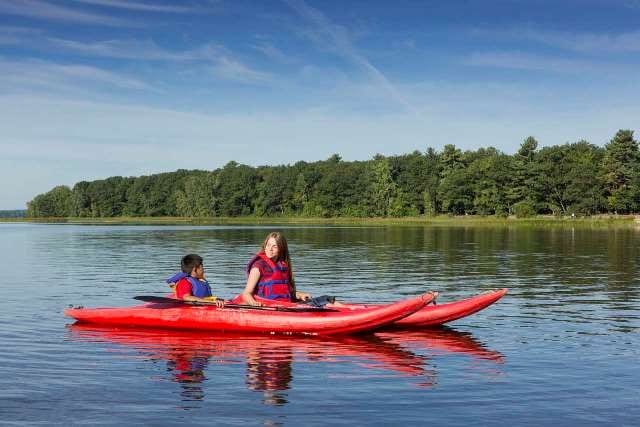 Deux enfants dans deux kayaks rouges 